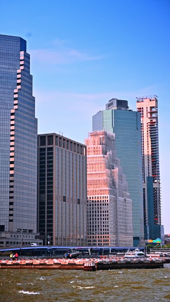 Arranha-céu alto em construção no centro de Nova York. Vista de um arranha-céu moderno em construção na cidade de Nova York, cercado por edifícios altos de vidro perto da orla.