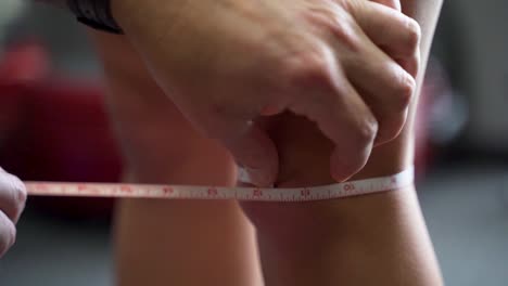 physiotherapist measuring diameter of patients knee