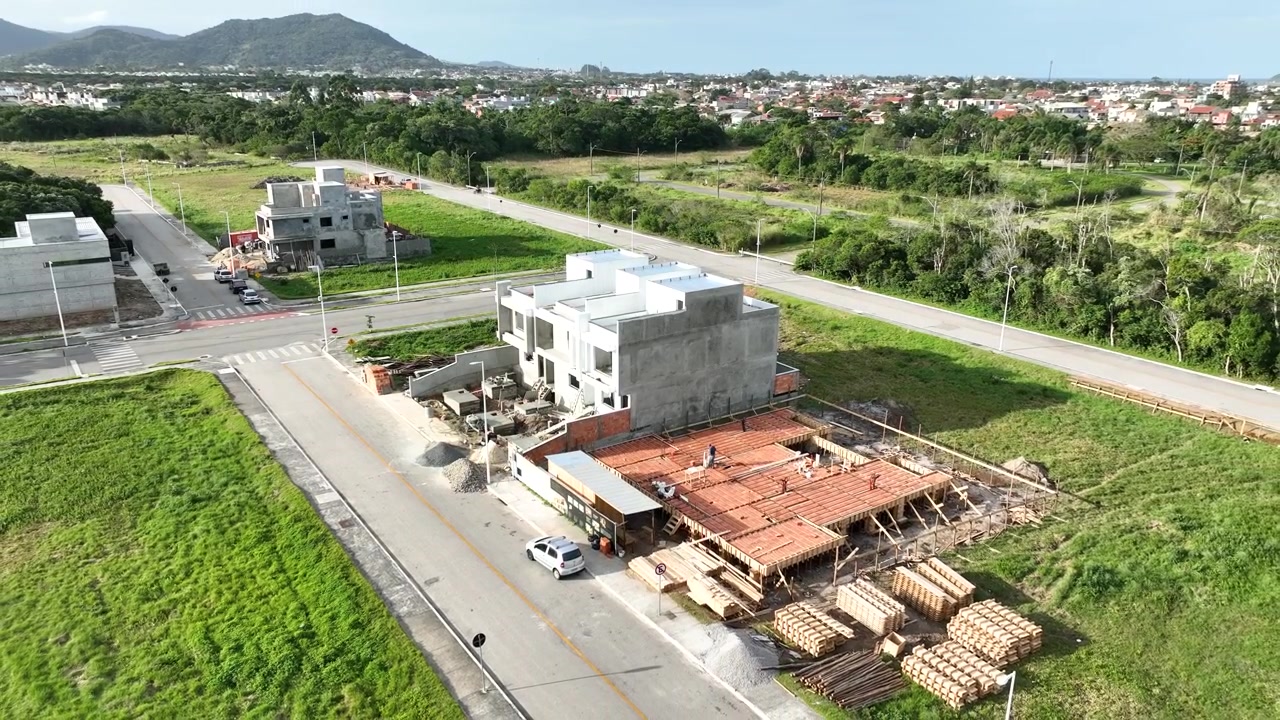 Aerial view of modern residential houses under construction using precast concrete elements with workers on site in Florianopolis, Santa Catarina, Brazil.