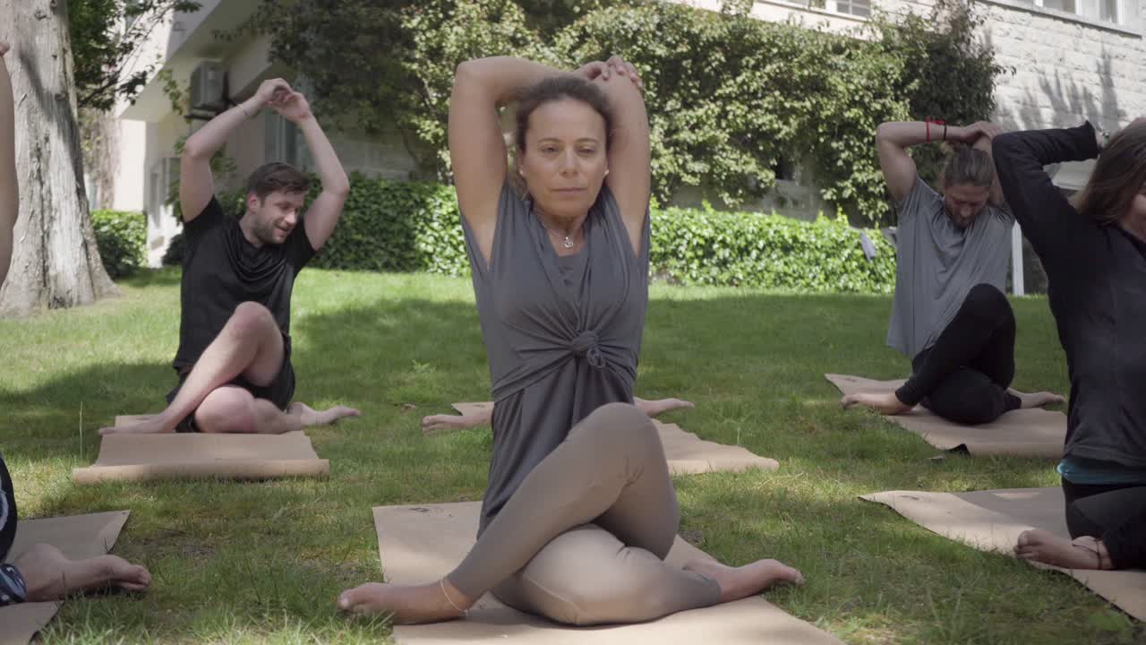 personas sentadas en esteras de yoga y practicando yoga al aire libre