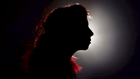 cinemagraph - silhouette redhead woman's hair blows in the wind