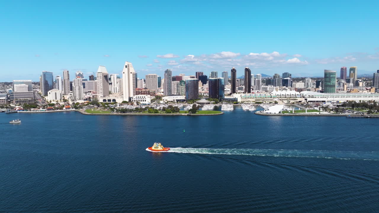 Boat Sailing In San Diego Bay With Downtown Skyline In The Background In San Diego, California, USA. - aerial shot