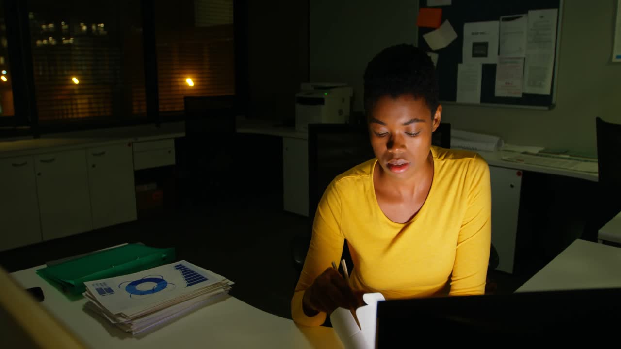 Female executive having noodles while working on computer 4k