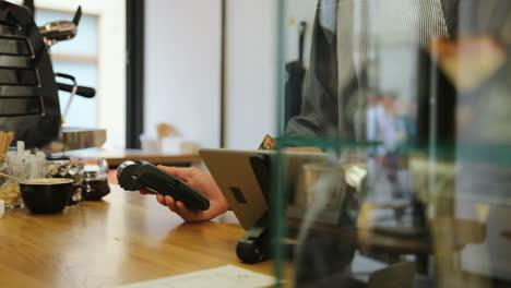 close-up view of barista hands making payment for the coffee with the credit card of a customer