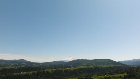 aerial view tilting over rural oregon with snowy mt hood background, in sunny usa