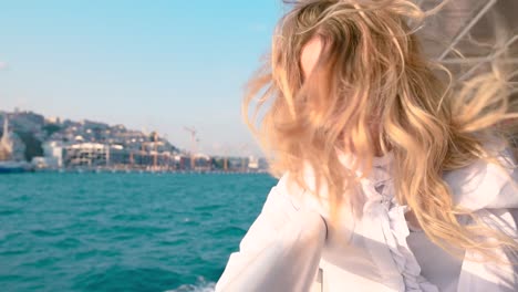 Slow-Motion:Beautiful-girl-enjoys-moment-while-cruising-with-view-of-sea-on-background