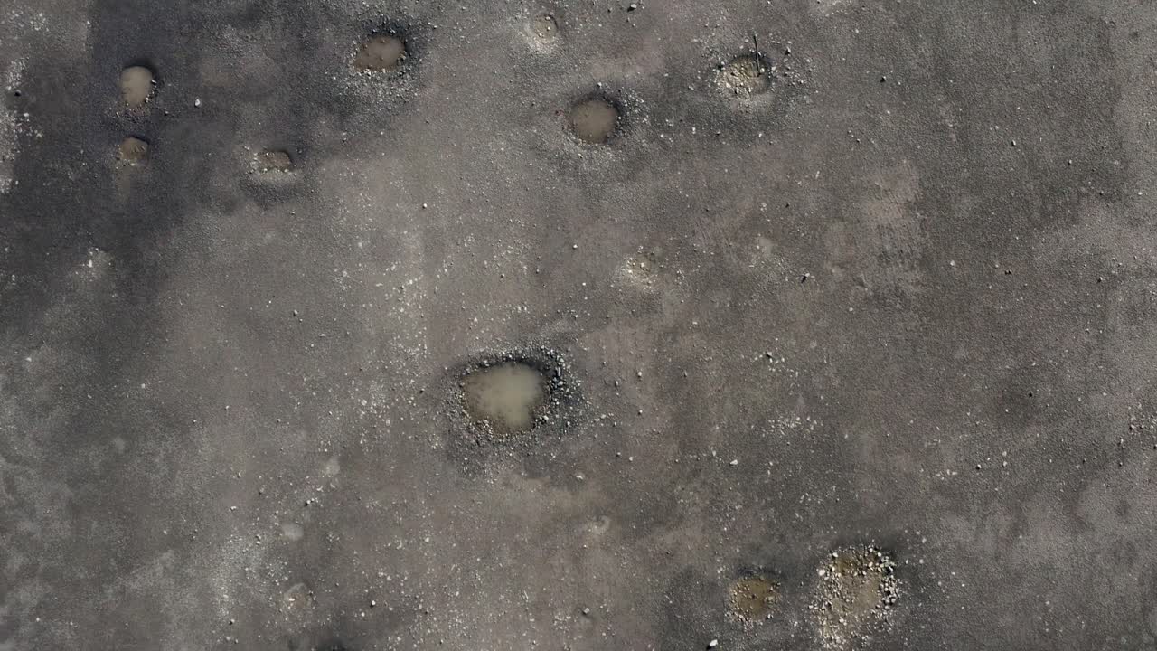 An abstract smooth shot over muddy puddles, footprints and soil on a farmyard | Edinburgh, Scotland | 4K at 30fps