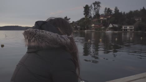 mujer sentada junto al lago