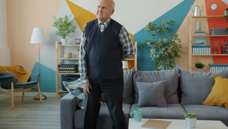 elderly man experiencing back pain at home