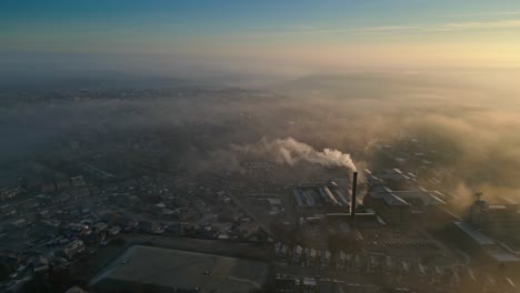 aerial drone shot above industrial urban townscape areas shrouded in morning mist