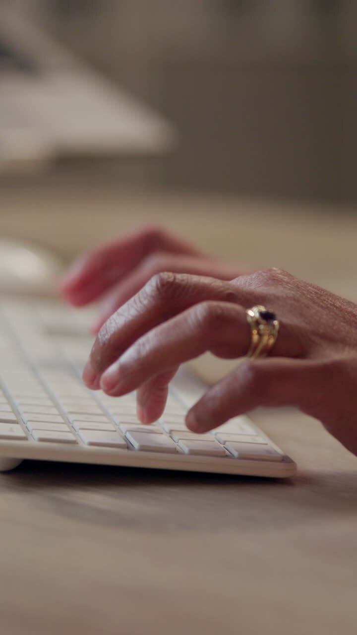 Woman's hands typing on a keyboard