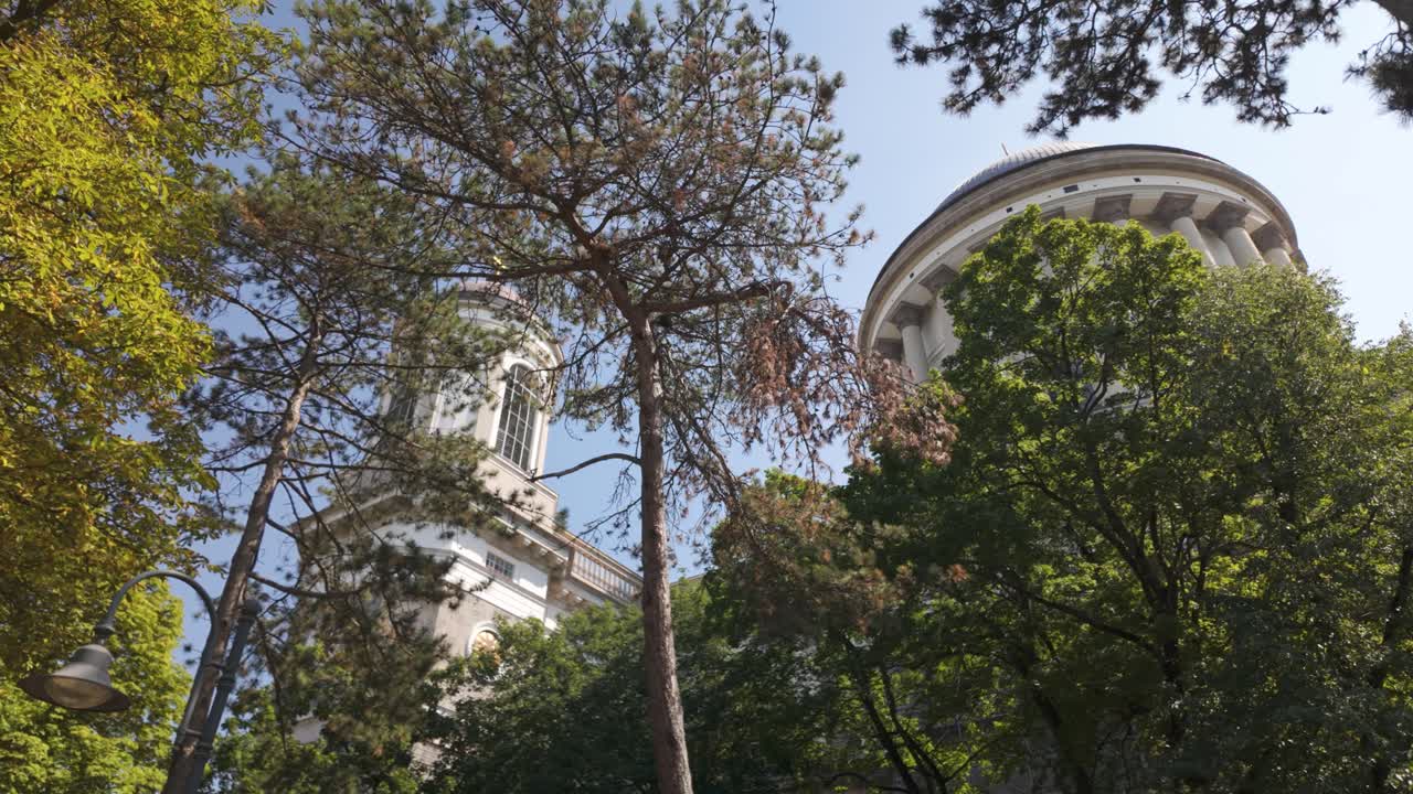 Low angle view of Esztergom Basilica dome and tower framed by trees in Hungary