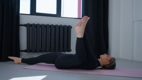 mujer haciendo estiramientos de yoga en una alfombra
