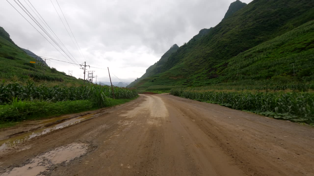 Scenic Dirt Road Through Lush Green Mountains in Vietnam