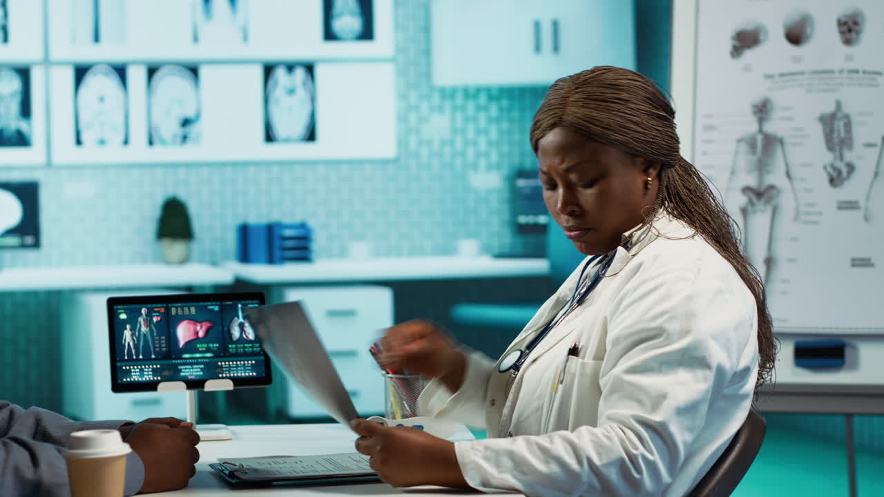 General practitioner reviewing x ray imaging at checkup with male patient