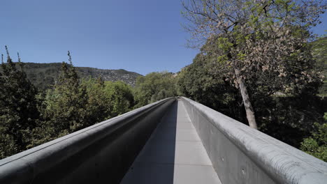 Spaziergang-Auf-Einer-Schmalen-Grauen-Brücke-Aus-Der-Ersten-Person-Im-Wald-Im-Süden-Frankreichs