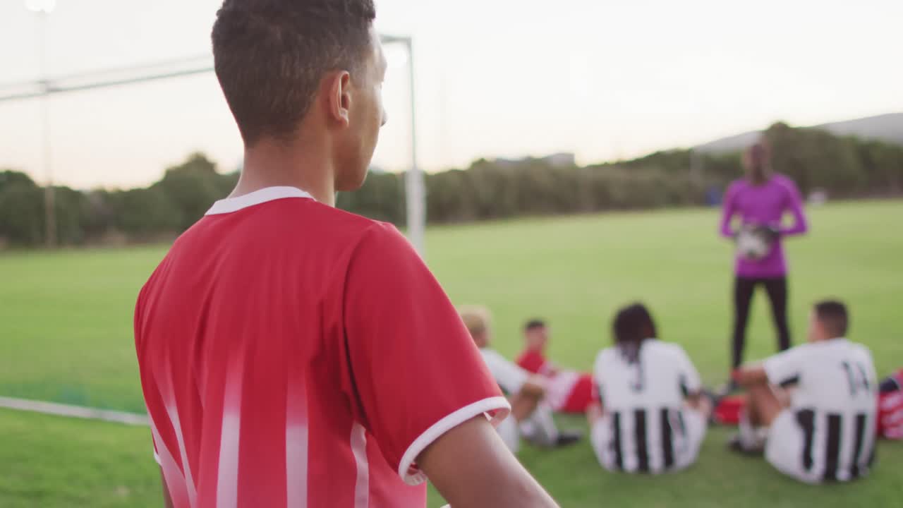 Video di un calciatore birazziale in campo con il pallone.