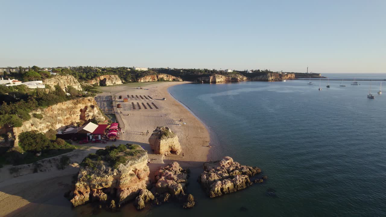 Drone flyover Rock formations from Praia grande in Portim&atilde;o by Arade River, Algarve