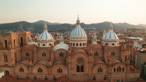 stunning aerial drone shot of the historic center of cuenca, ecuador, highlighting the iconic blue domes of the cathedral of the immaculate conception.
