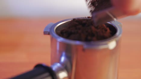 putting the freshly ground coffee inside the porta filter macro shot