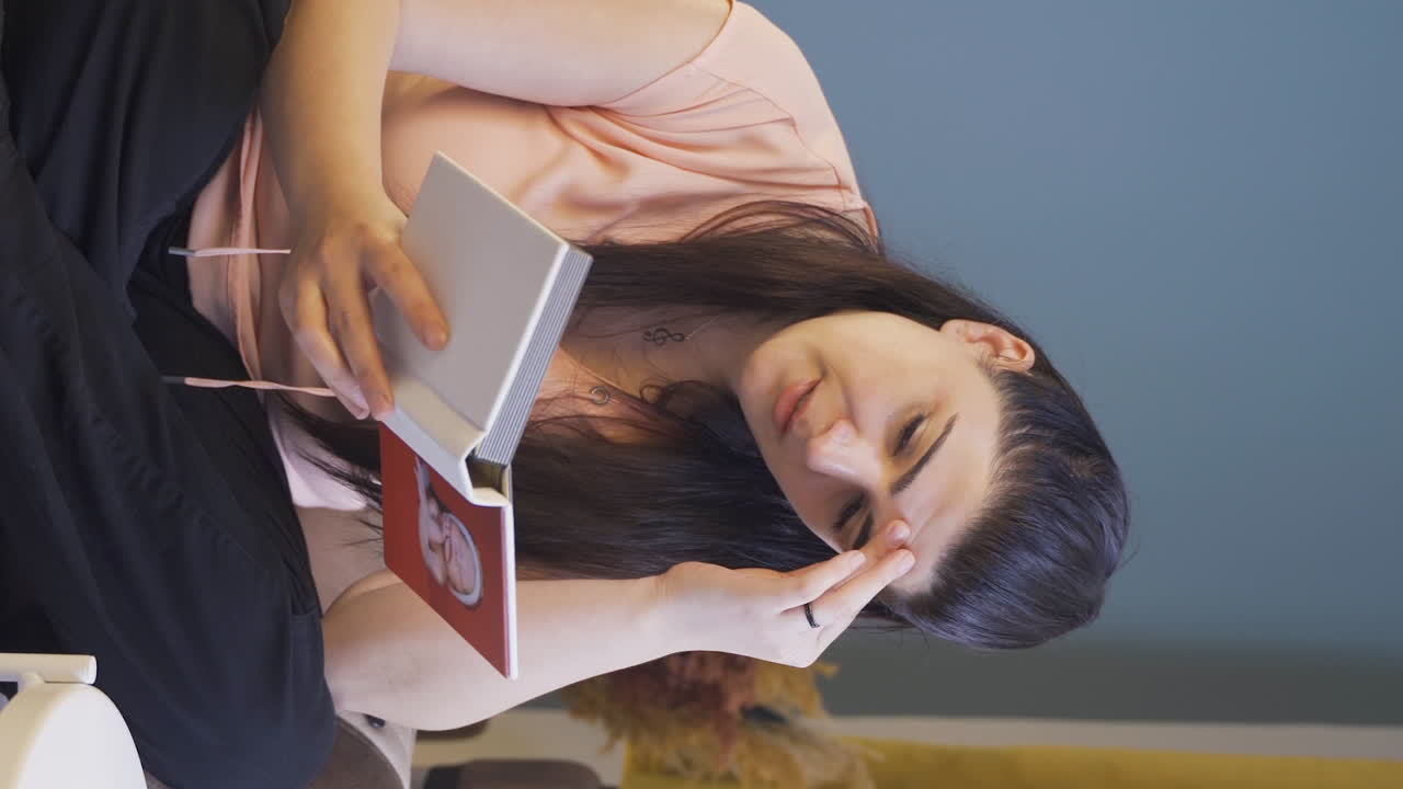 Video vertical de la mujer deprimida mirando el álbum familiar.