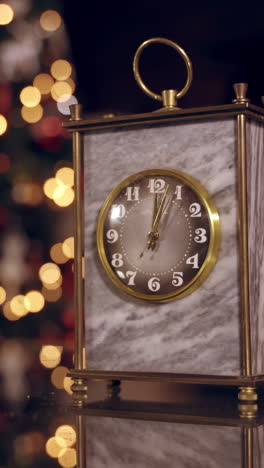 nice clock on blur christmas background. clock is showing midnight. it's twelve o'clock. happy new year time. christmas concept vertical video