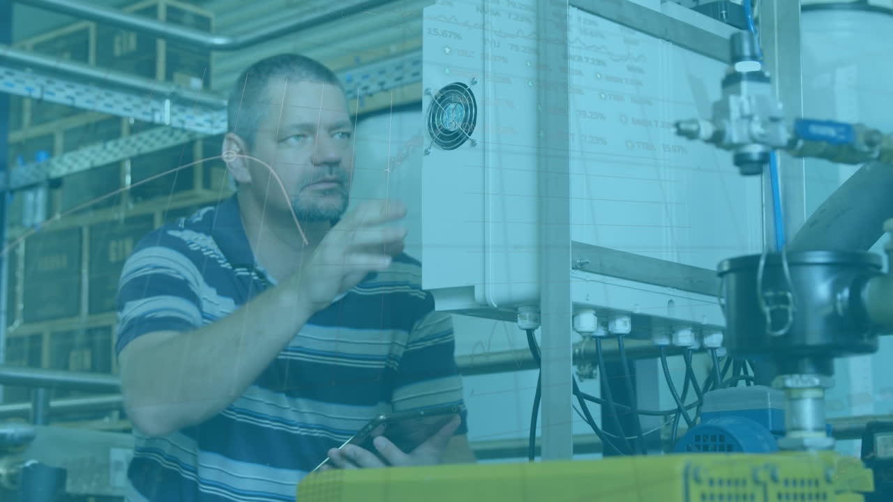Animation of financial data over caucasian male factory worker with tablet