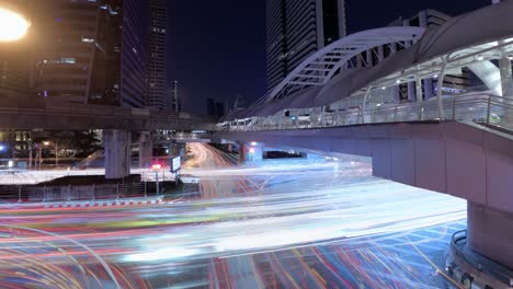 Lapso-Nocturno-De-Exposición-Prolongada-Del-Tráfico-Y-La-Intersección-Ocupada-En-El-Puente-Chong-Nonsi-En-Bangkok,-Tailandia