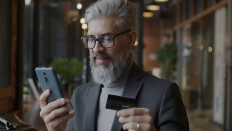 man making mobile payment in a cafe