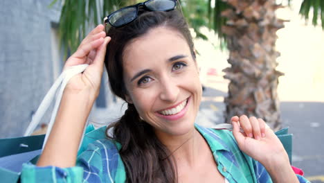retrato de una mujer atractiva sonriendo y sosteniendo bolsas de compras