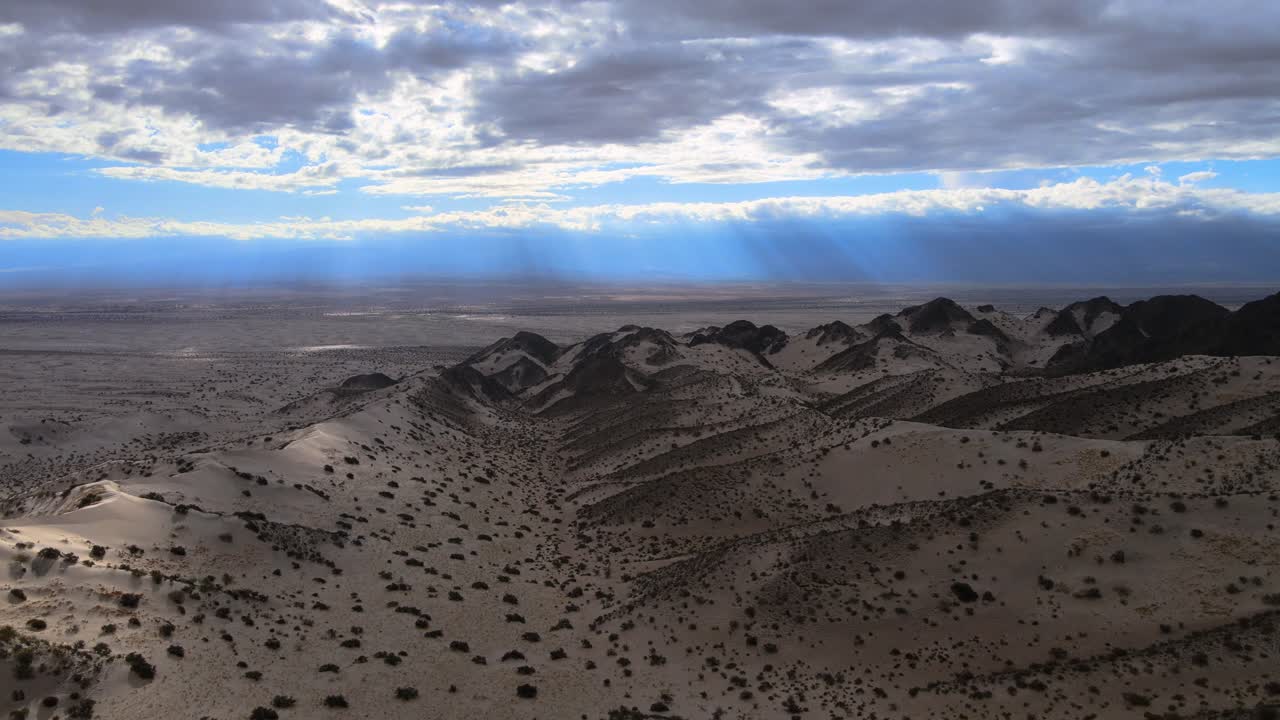 Drone shot flying over the Dunes of Tat&oacute;n in Catamarca, Argentina during overcast conditons with light rays in the distance