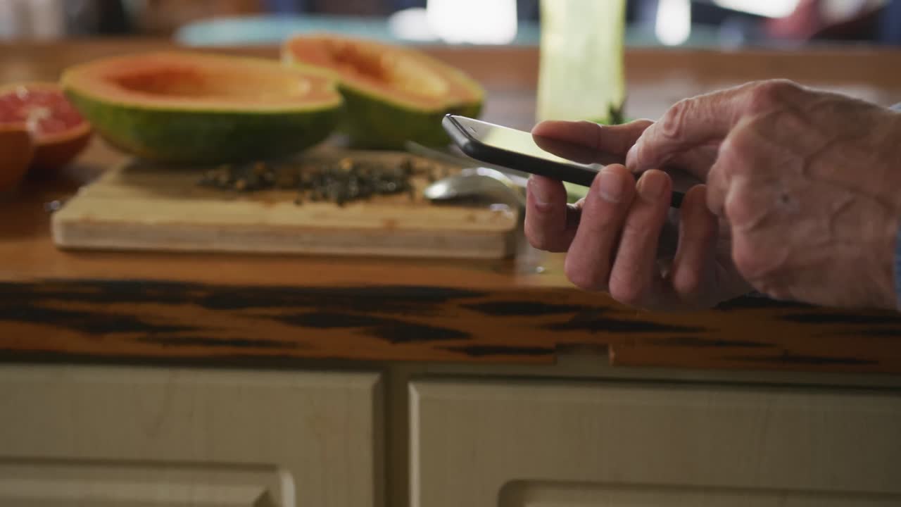 hombre mayor usando teléfono móvil en casa