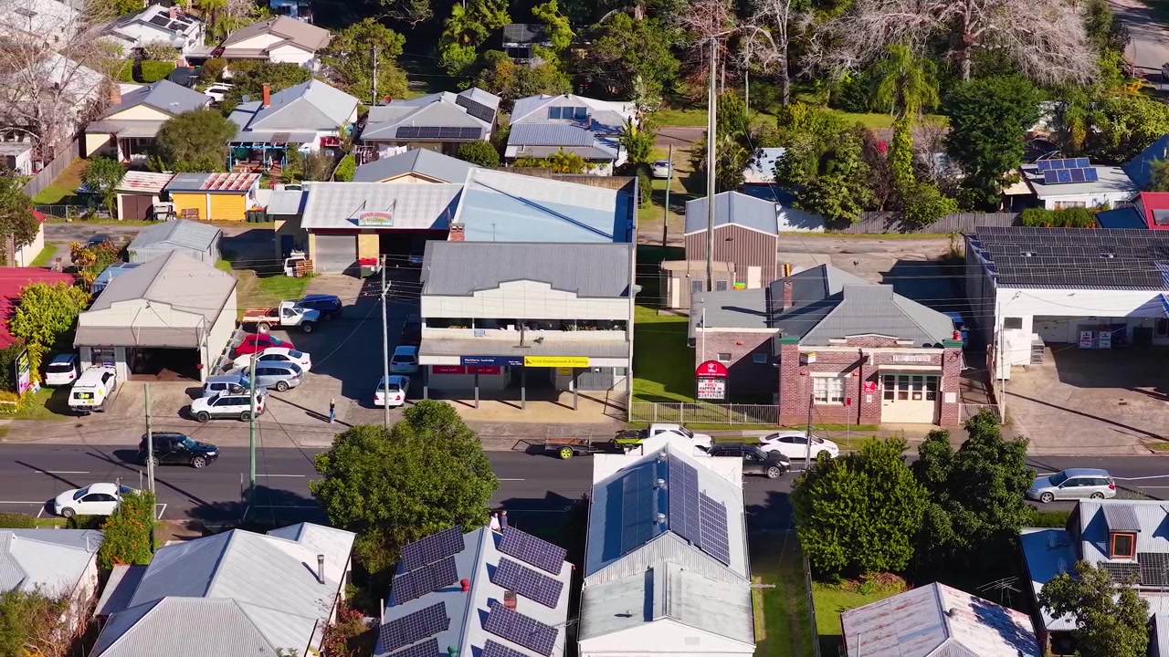 オーストラリアの明るい日差しの下、住宅の屋根と商業ビルを映し出す高角度のドローンショット