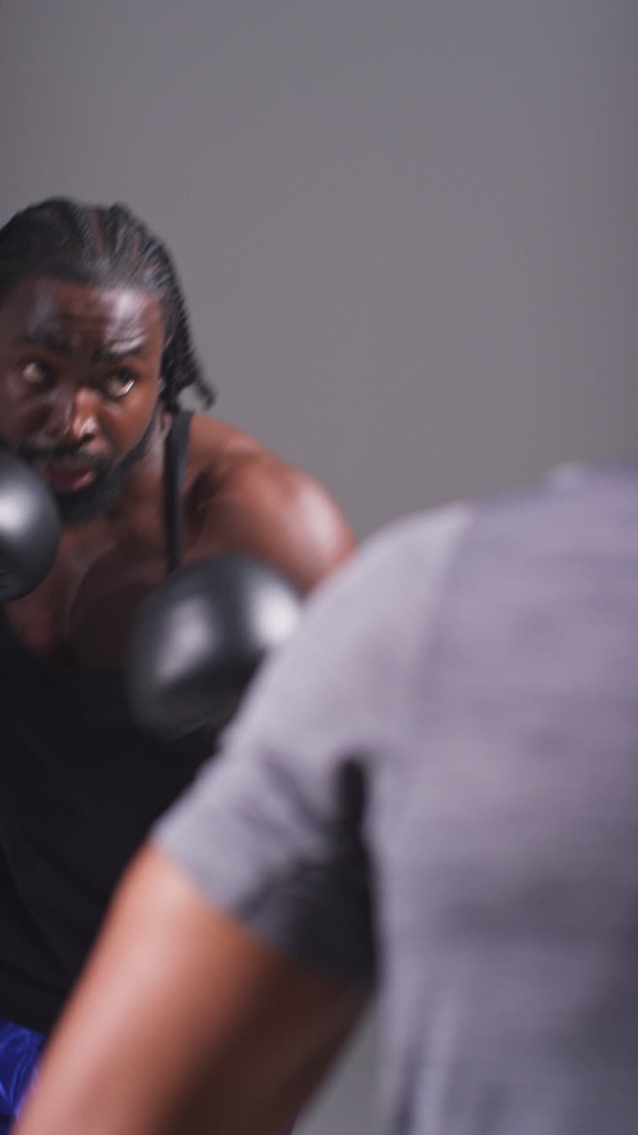 Vertical Video Studio Shot Of Male Boxer Sparring Working Out With Trainer Wearing Punch Mitts Or Gloves Practising For Fight 3
