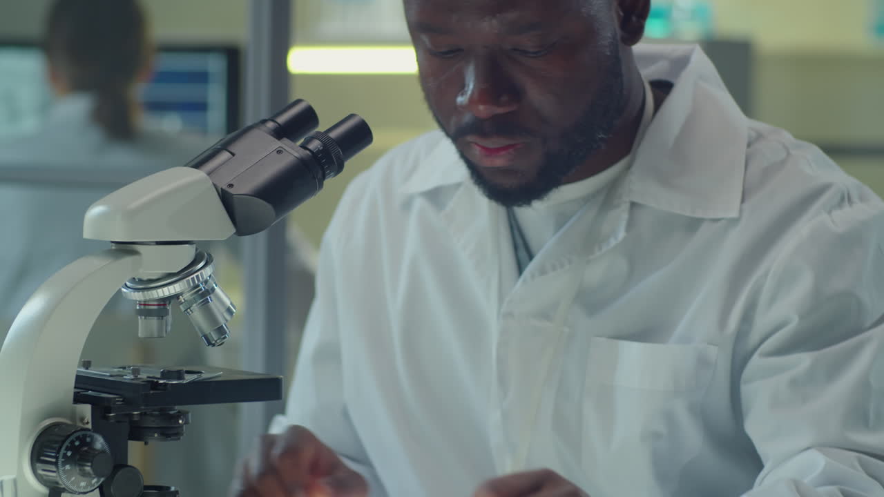 African American Scientist Using Microscope in Laboratory