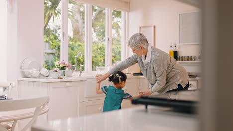 Dancing,-child-and-grandmother-in-family-home