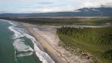 waves crashing in the sandy shoreline of maori beach in south island, new zealand. - aerial shot