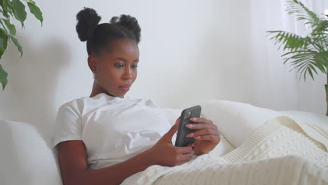 woman using smartphone in bed