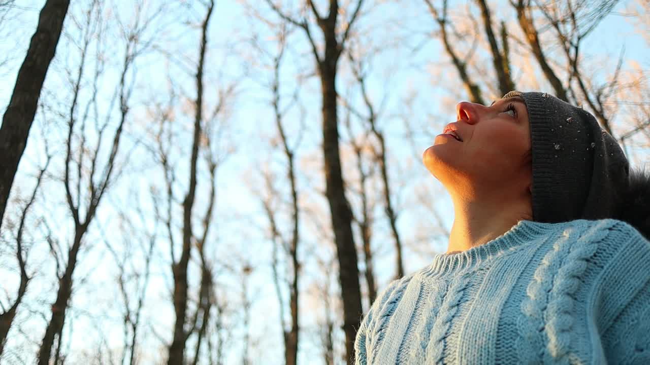 백인 소녀는 빨간 머리를 드러내는 그녀의 모자를 벗고, 숲에서 일몰 슬로우 모션 샷