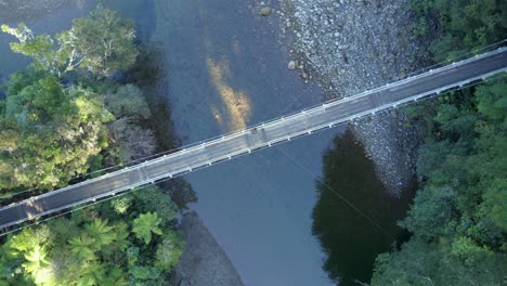 a rotating drone shot of a swing bridge crossing a river