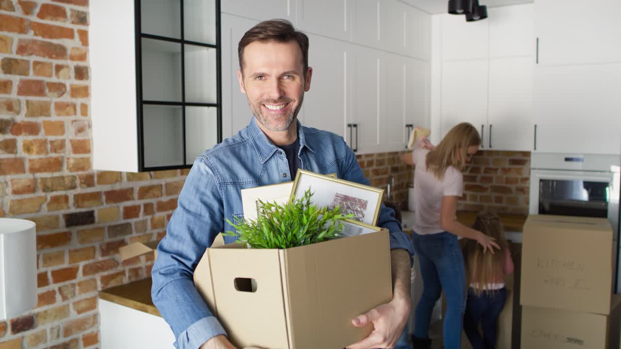 retrato de video de un hombre sonriente sosteniendo una caja de cartón durante el movimiento