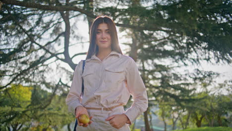 beautiful woman standing park holding fresh apple closeup. girl posing sunlight