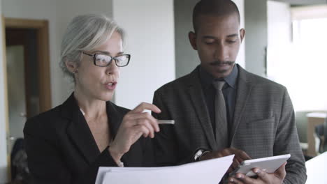 mentor en stagiair die financiële grafieken bestuderen