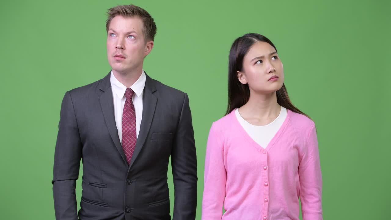 Young Asian woman and young businessman thinking together