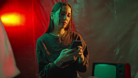 woman using smartphone in neon lit room with vintage tv