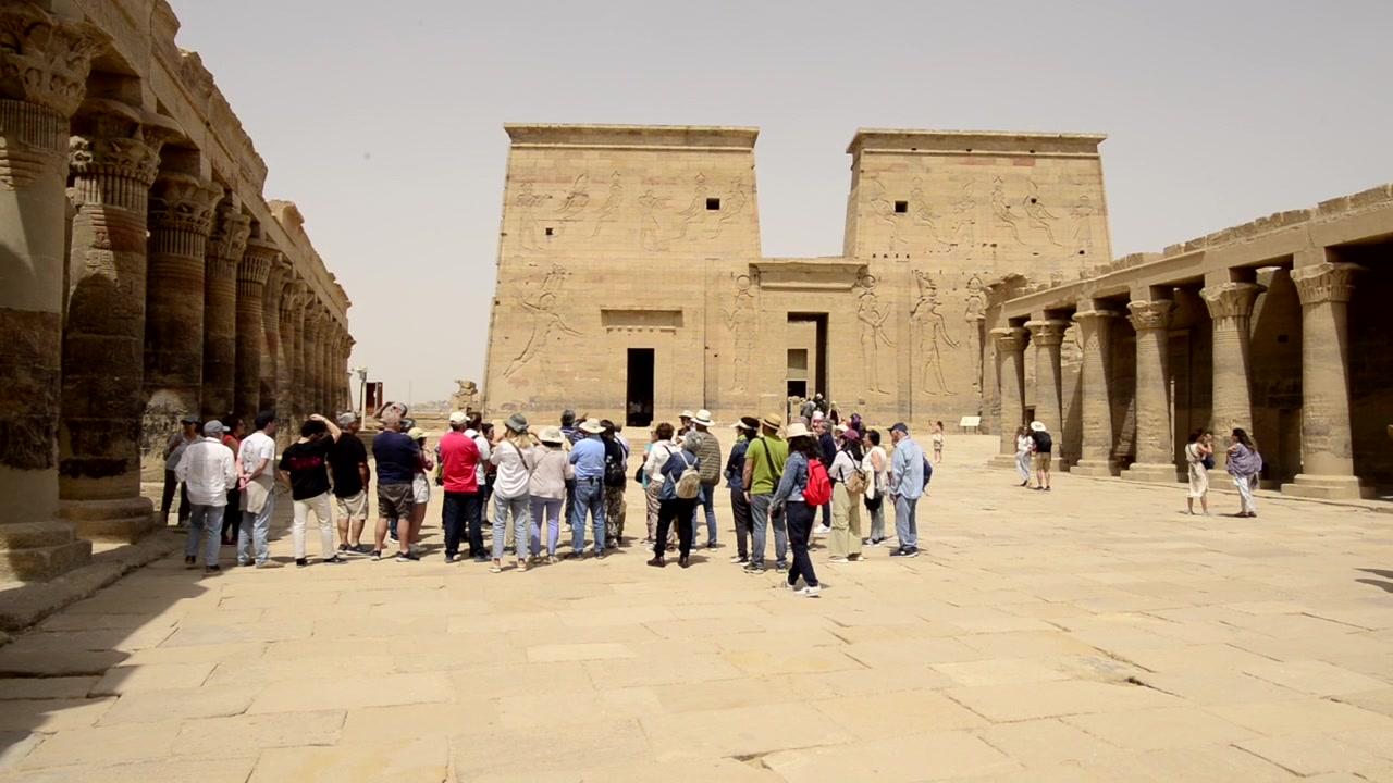 Gruppo di turisti fuori dal Tempio di File in Egitto. Tour al Tempio di File della dea Iside. Viaggio per ammirare la facciata dell'edificio del Tempio egizio di Iside a File o Philae. Escursione di turismo mondiale