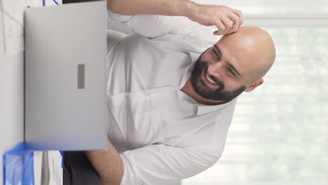 Vertical-video-of-Home-office-worker-man-experiencing-joy.