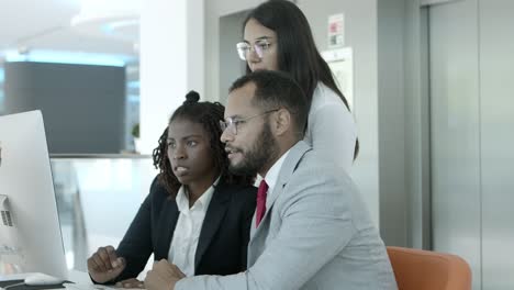 compañeros de trabajo concentrados usando computadora de escritorio