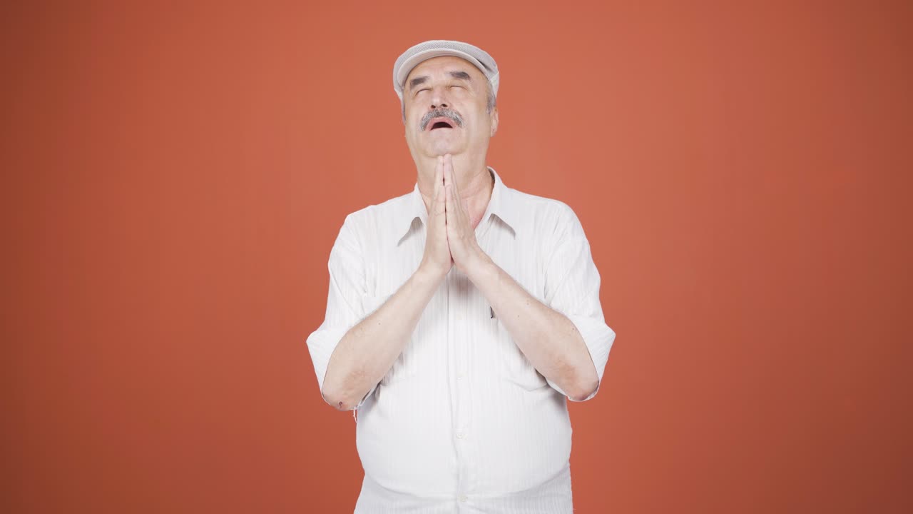 카메라를 쳐다보며 명상하는 노인.