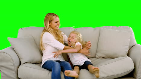 Daughter-jumping-in-the-arms-of-her-mother-on-green-screen